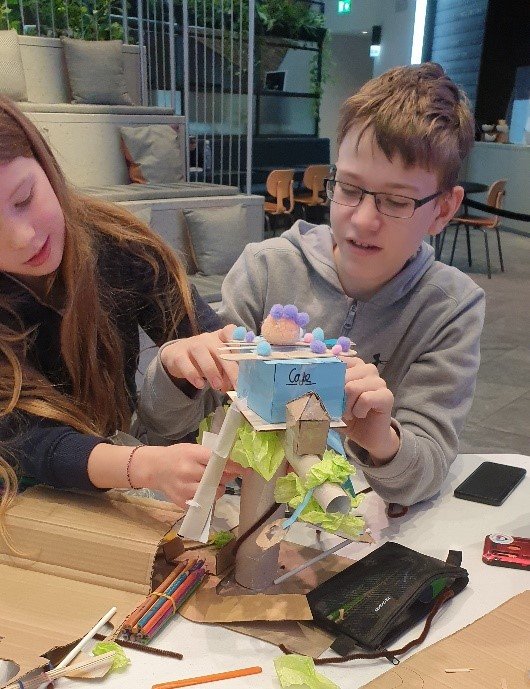 Two children building a colourful model together