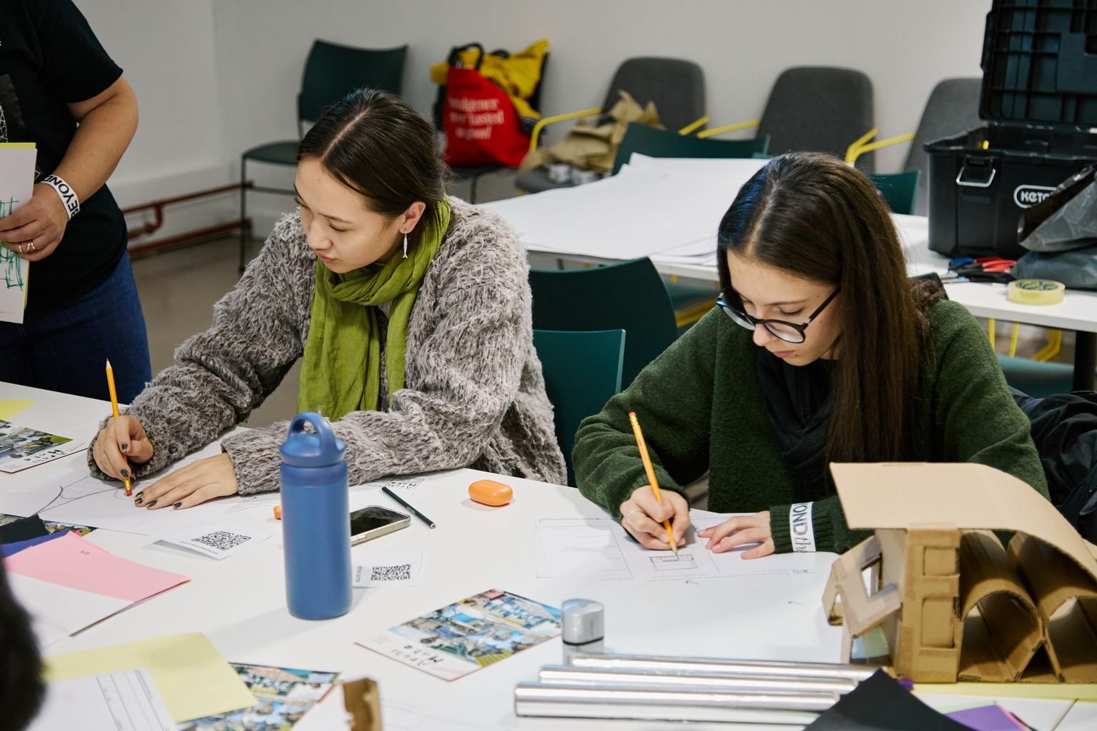 Two teenage girls sketching designs by hand