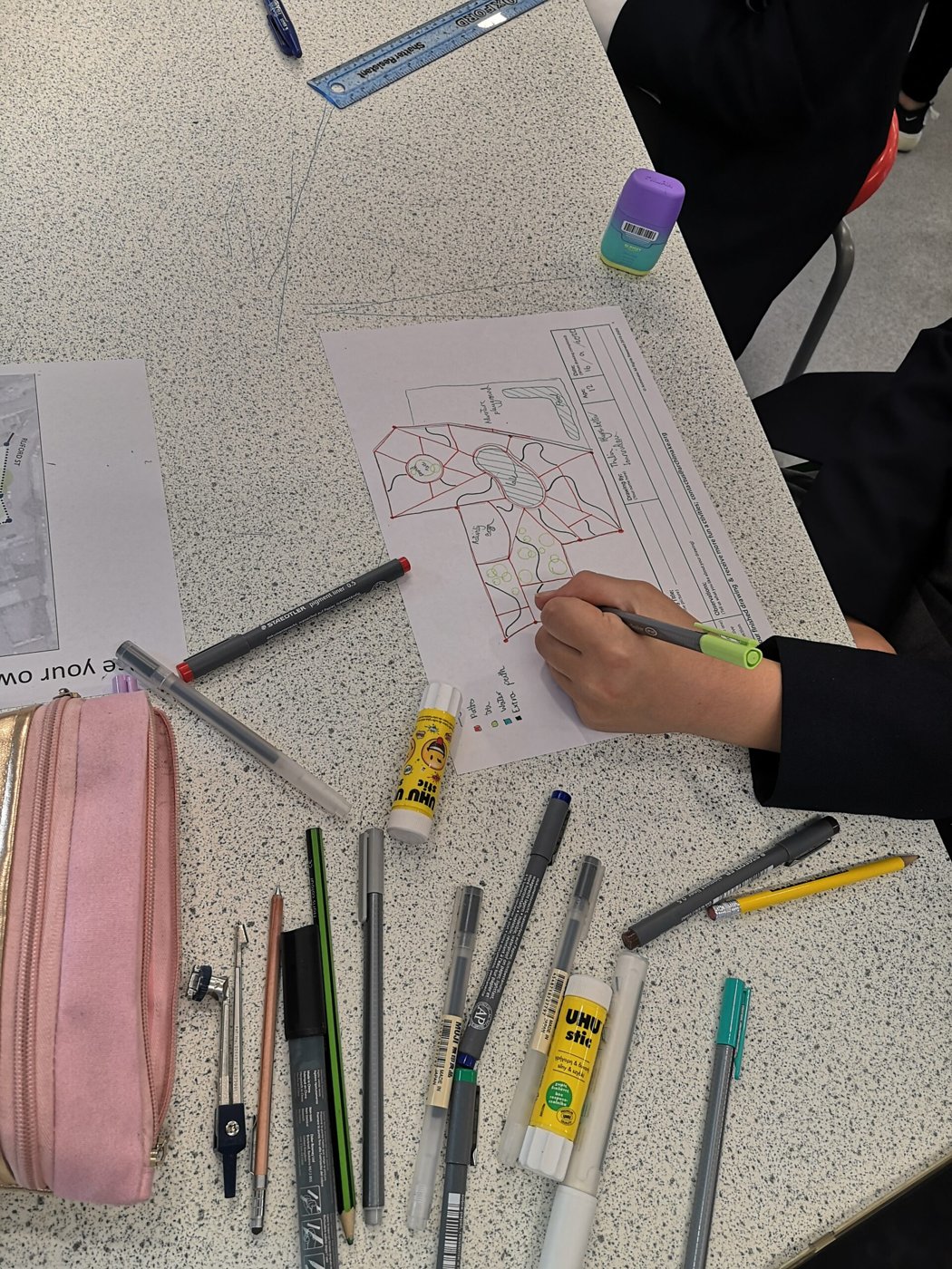 A child drawing a design plan by hand at an Archimake workshop